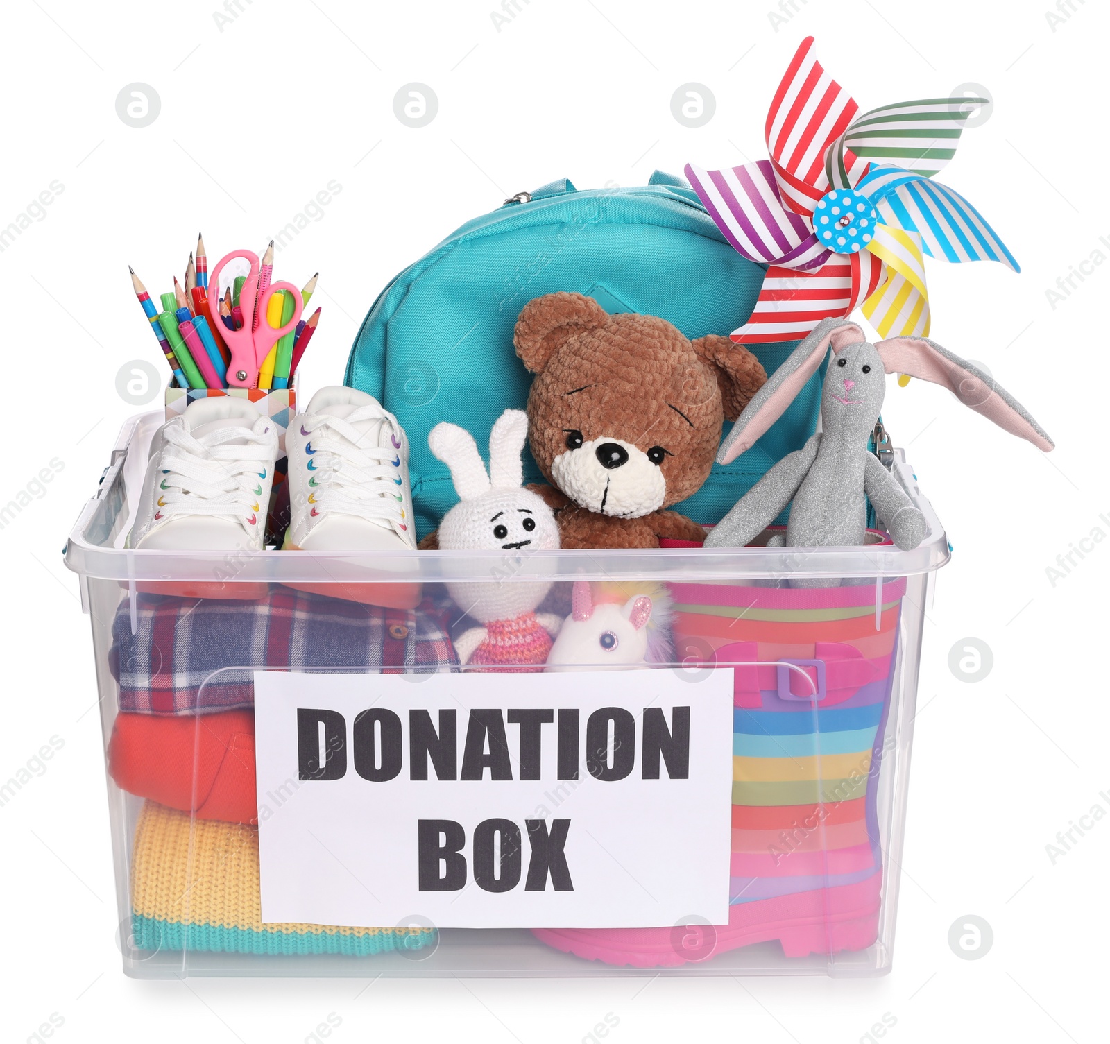 Photo of Donation box full of different toys, clothes and stationery isolated on white