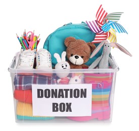 Photo of Donation box full of different toys, clothes and stationery isolated on white