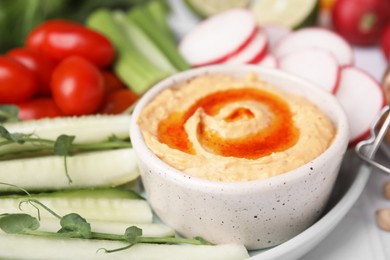 Photo of Plate with delicious hummus and fresh vegetables on table, closeup