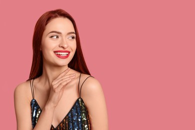 Happy woman with red dyed hair on pink background, space for text