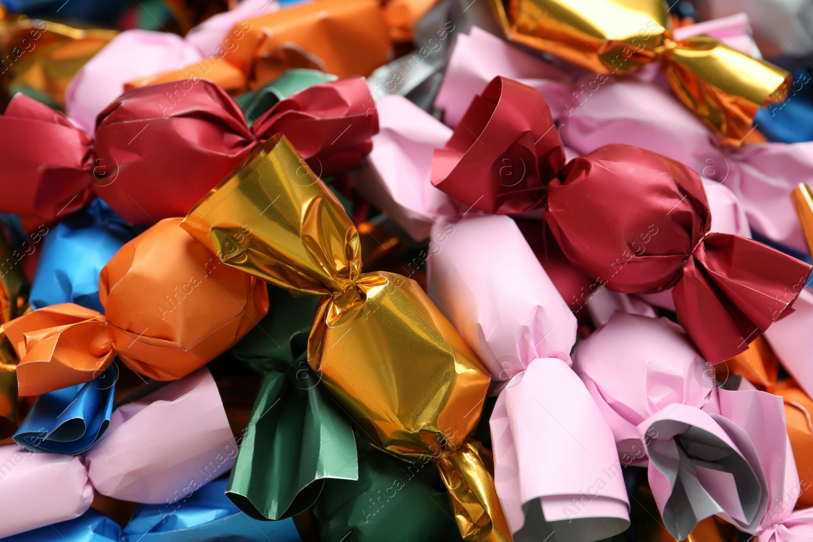 Photo of Many candies in colorful wrappers as background, closeup