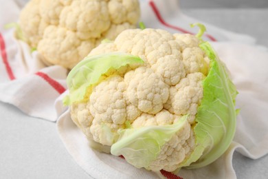 Photo of Whole fresh raw cauliflowers on white table, closeup