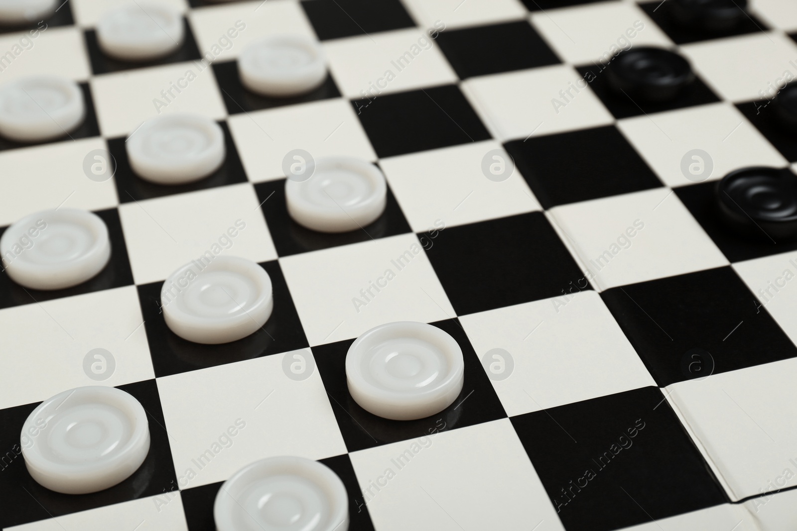 Photo of Checkerboard with game pieces as background, closeup