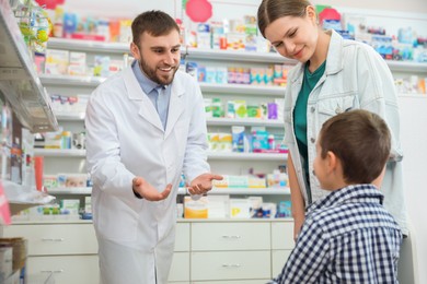 Professional pharmacist working with customer in modern drugstore