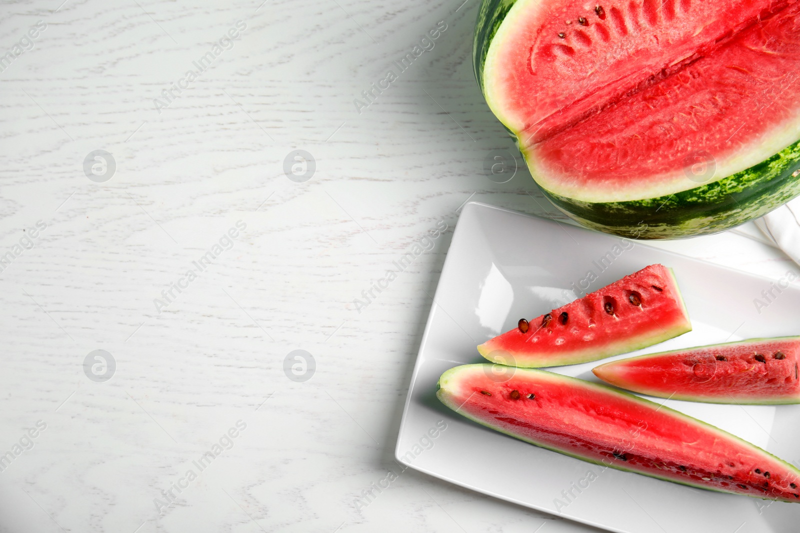 Photo of Yummy watermelon on white wooden table, flat lay. Space for text