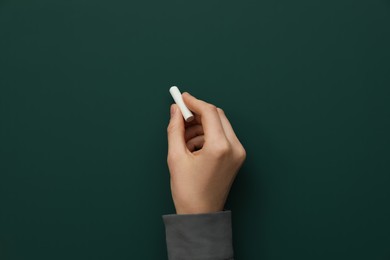 Photo of Woman with white chalk near green board, closeup. Space for text