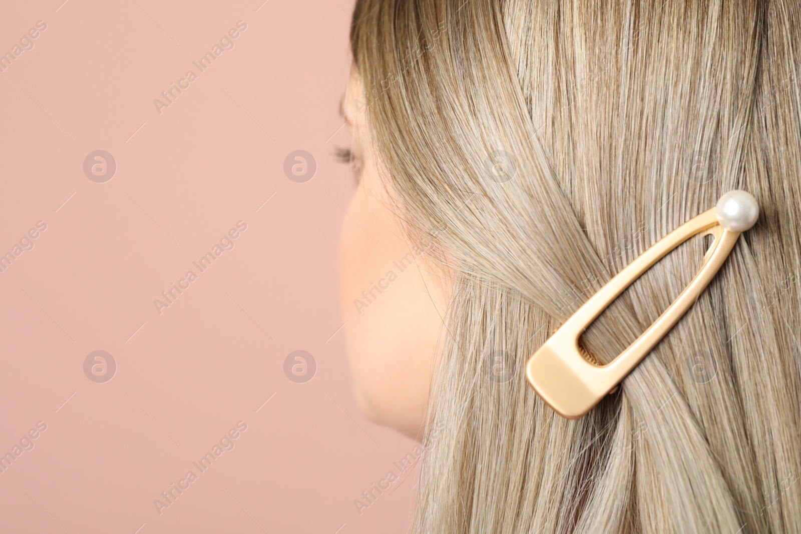 Photo of Young woman with beautiful hair clip on pink background, closeup