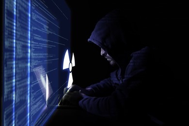 Image of Nuclear deterrence. Hacker using computer in darkness, virtual screen with code and warning radiation symbol