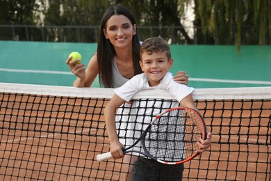 Mother with her son on tennis court