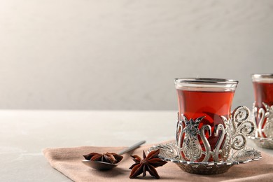 Glasses of traditional Turkish tea in vintage holders and anise stars on table. Space for text