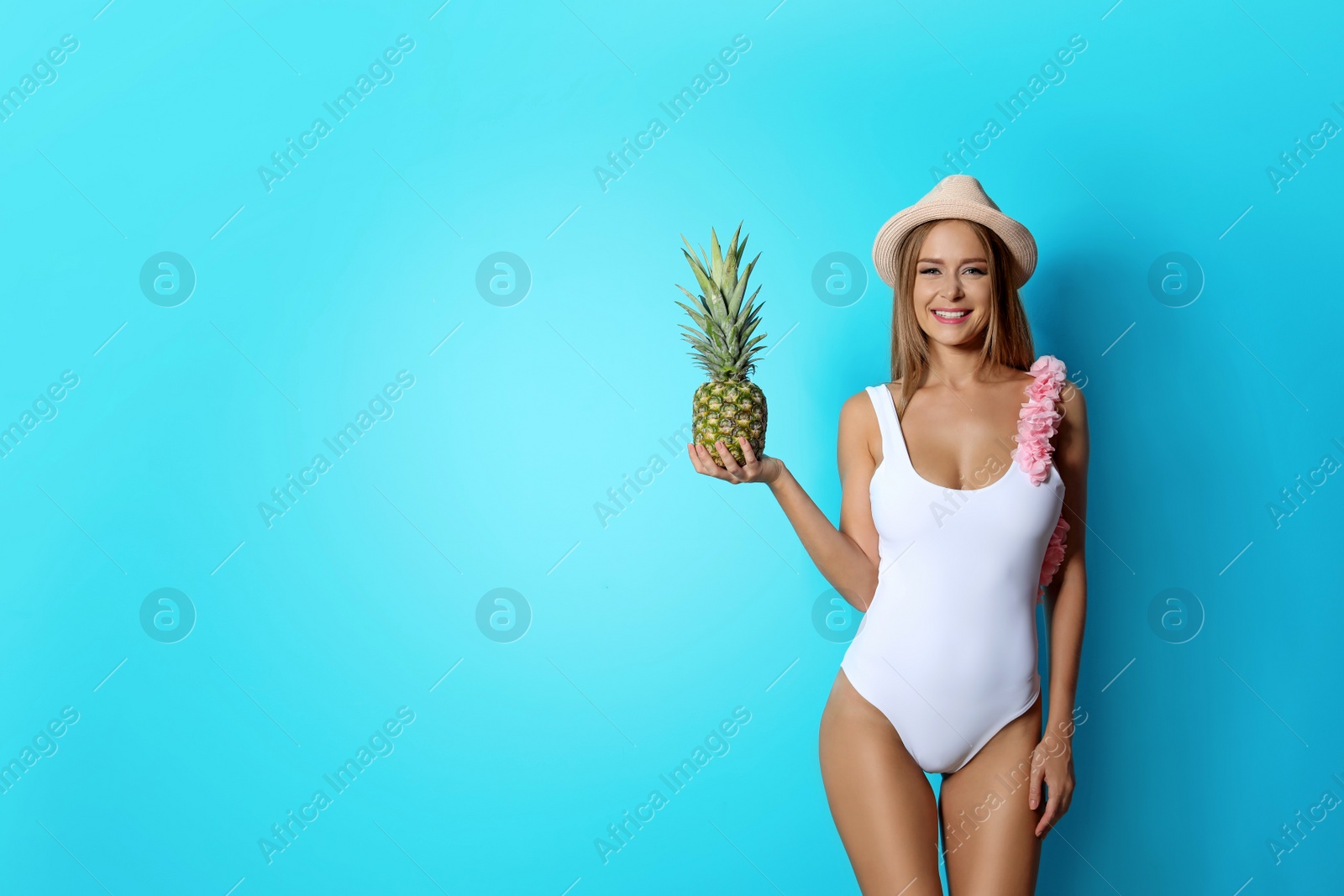 Photo of Sexy young woman in bikini with pineapple on color background