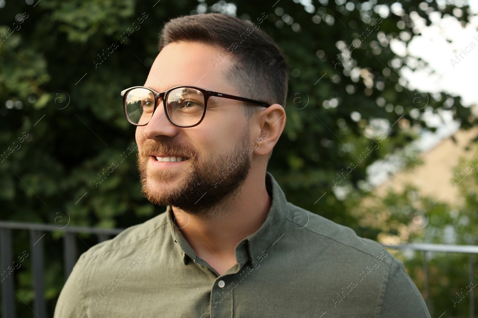 Photo of Portrait of handsome bearded man in glasses outdoors