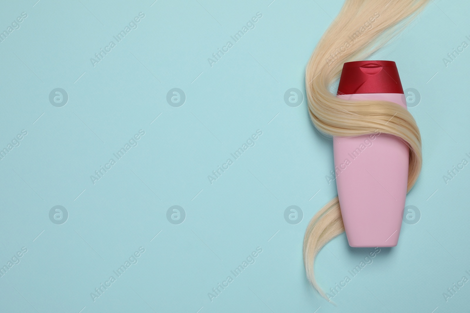 Photo of Lock of healthy blond hair and cosmetic product on turquoise background, flat lay. Space for text