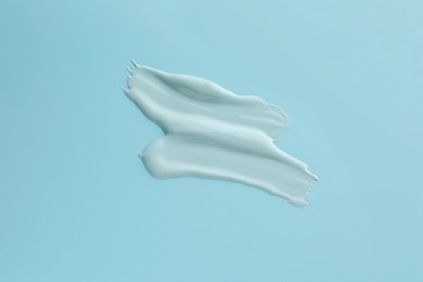 Photo of Samples of face mask on light blue background, top view