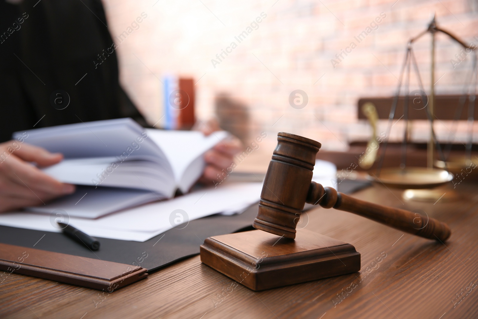 Photo of Judge working at table in office, focus on gavel. Law and justice concept