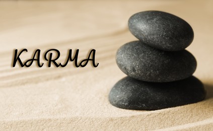 Image of Karma concept. Stacked stones on sand, closeup