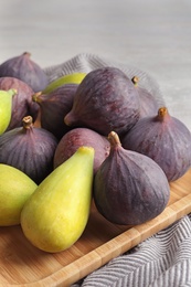 Photo of Plate with assorted ripe figs on table. Tropical fruit