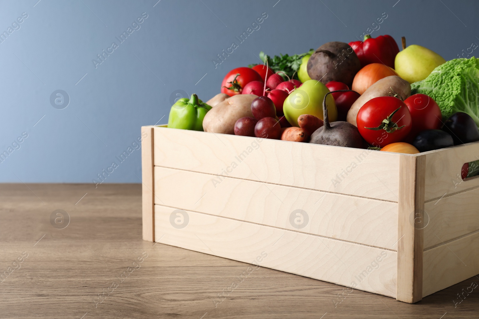 Photo of Crate full of different vegetables and fruits on wooden table. Harvesting time