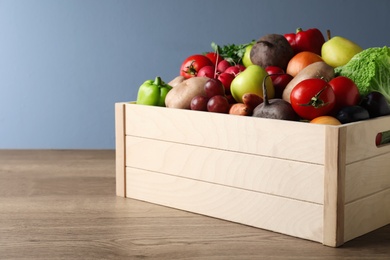 Photo of Crate full of different vegetables and fruits on wooden table. Harvesting time