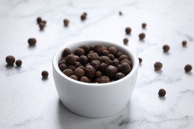 Photo of Black peppercorns in bowl on white marble table
