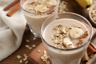 Photo of Tasty banana smoothie with oatmeal and cinnamon on table, closeup. Space for text