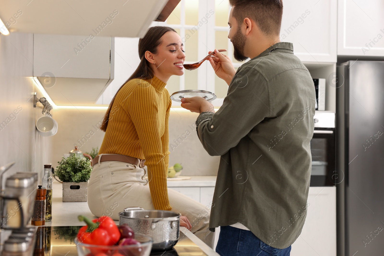 Photo of Lovely young couple cooking together in kitchen