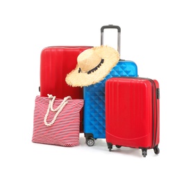 Photo of Packed suitcase with hat and hand-luggage on white background