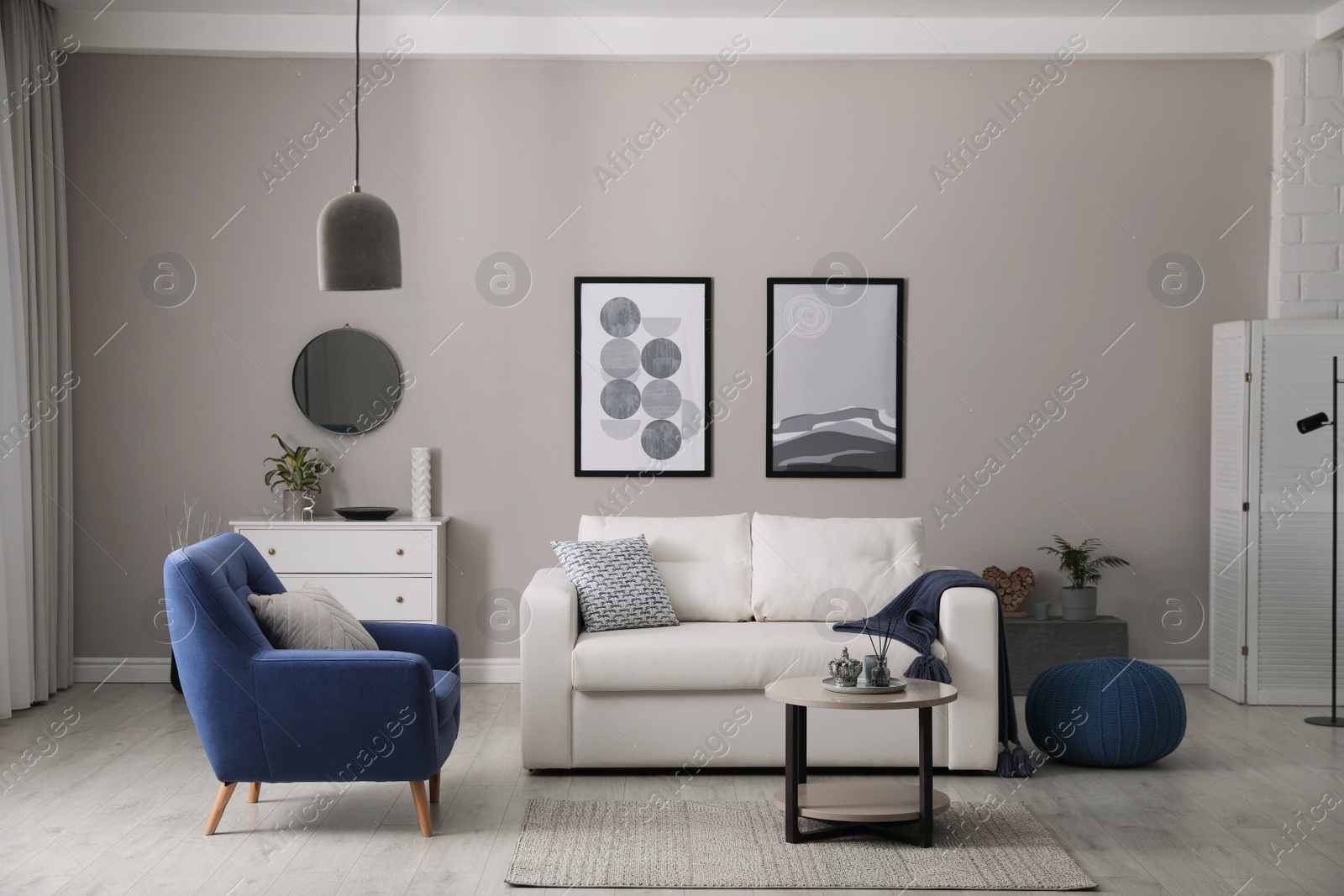 Photo of Stylish living room interior with white sofa, armchair and small coffee table