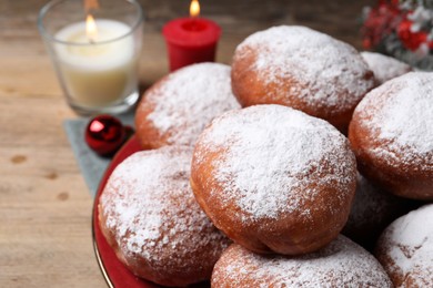 Delicious sweet buns and burning candles on table, closeup
