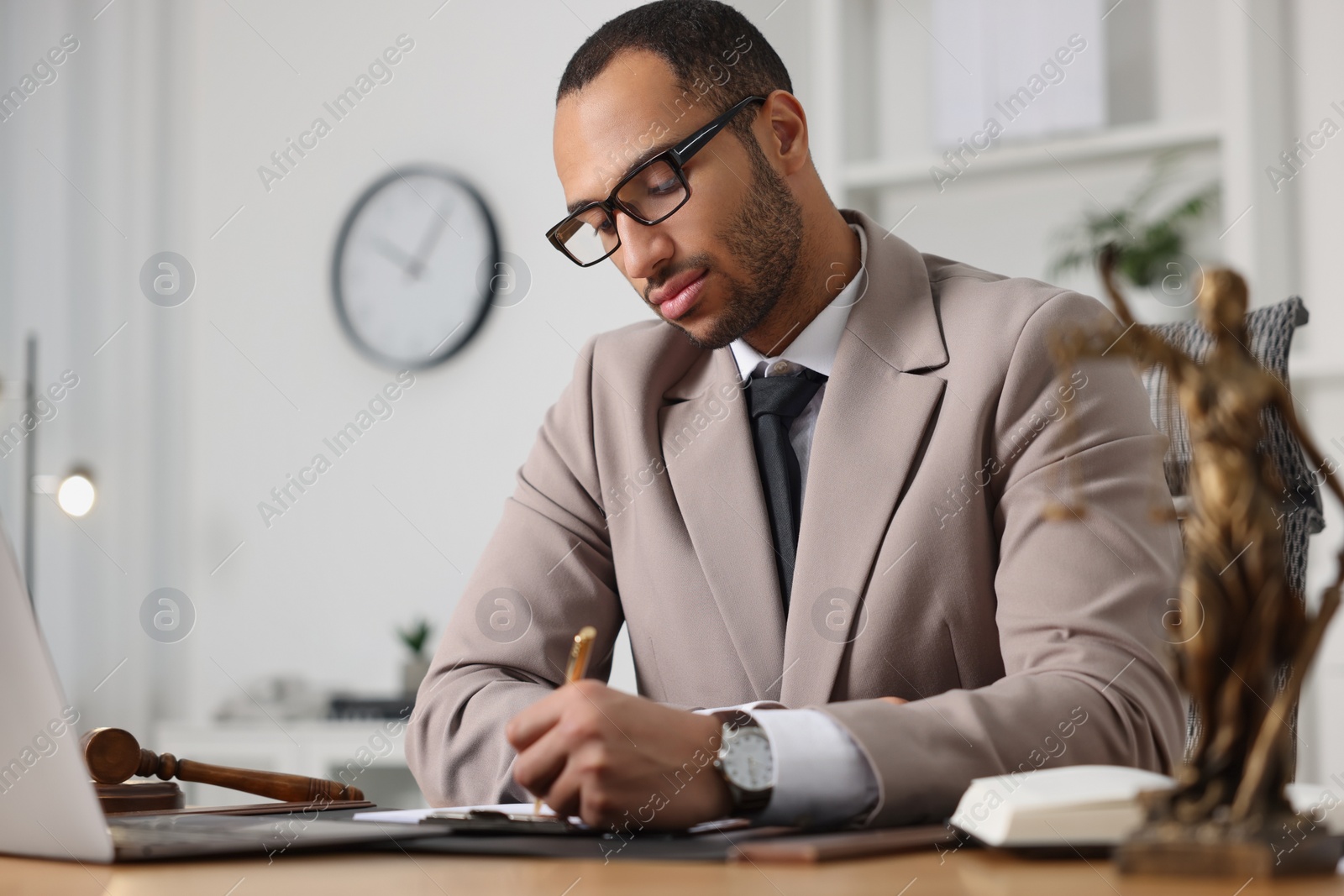 Photo of Serious lawyer working at table in office