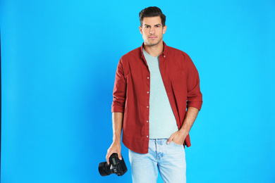 Photo of Professional photographer working on light blue background in studio