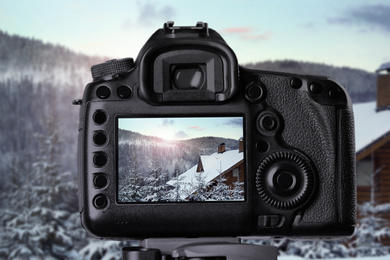 Recording beautiful view of snowy forest on professional video camera