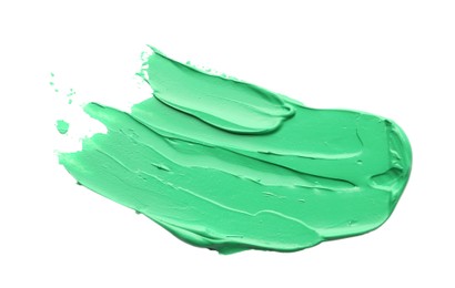 Photo of Green oil paint stroke on white background, top view