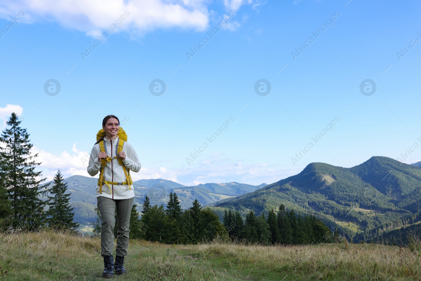 Photo of Tourist with backpack hiking through mountains, space for text