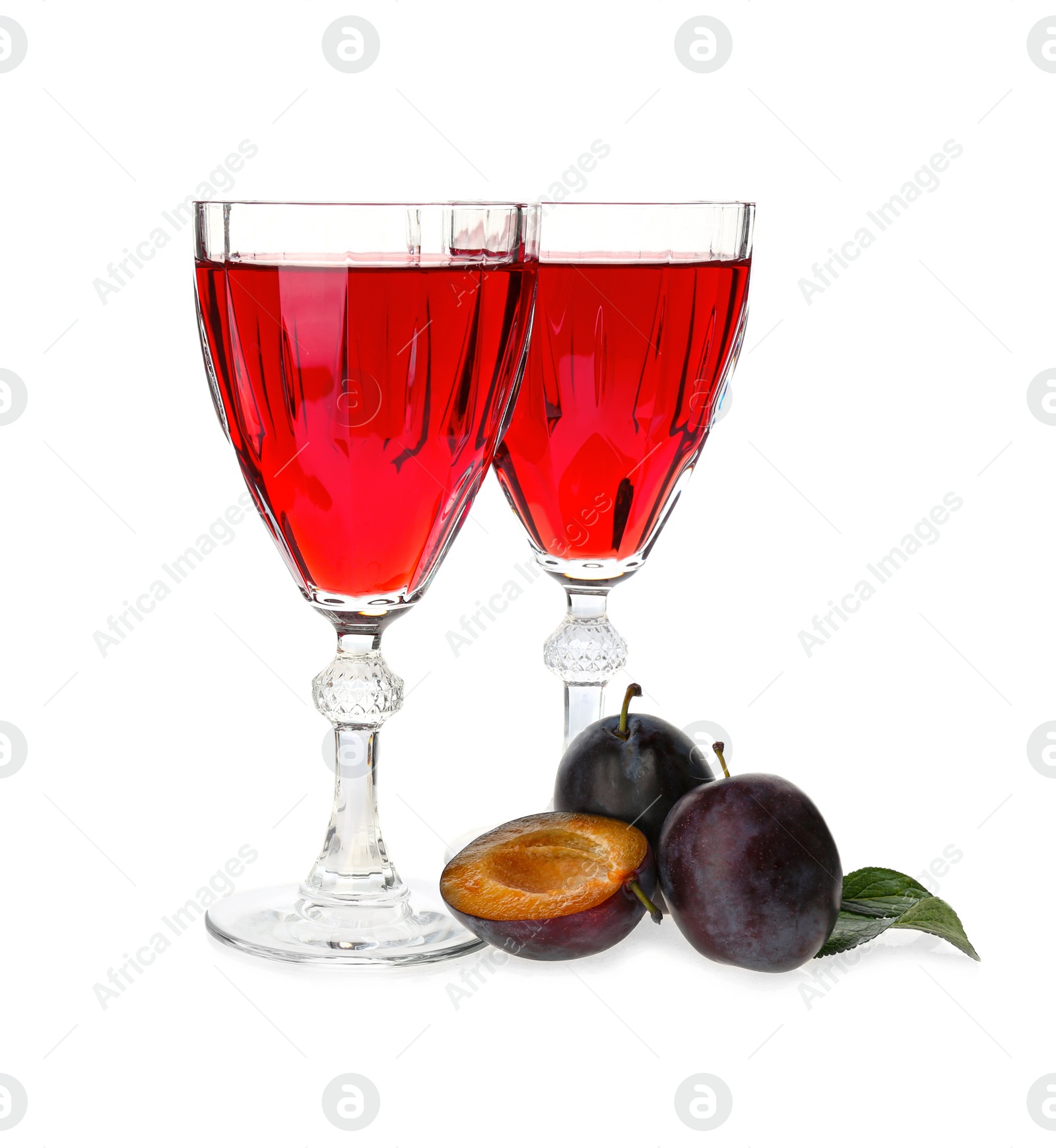 Photo of Delicious plum liquor and ripe fruits on white background. Homemade strong alcoholic beverage