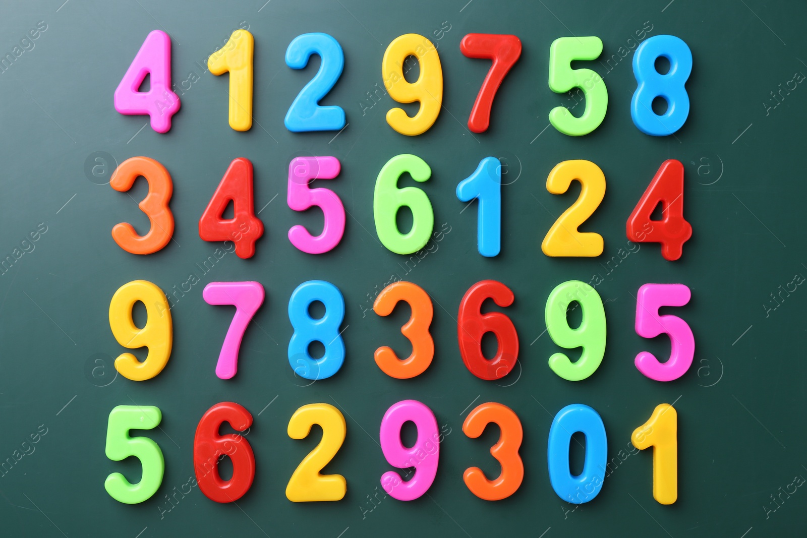 Photo of Colorful numbers on green background, flat lay