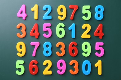 Photo of Colorful numbers on green background, flat lay