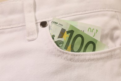 Euro banknote in pocket of white jeans, closeup. Spending money