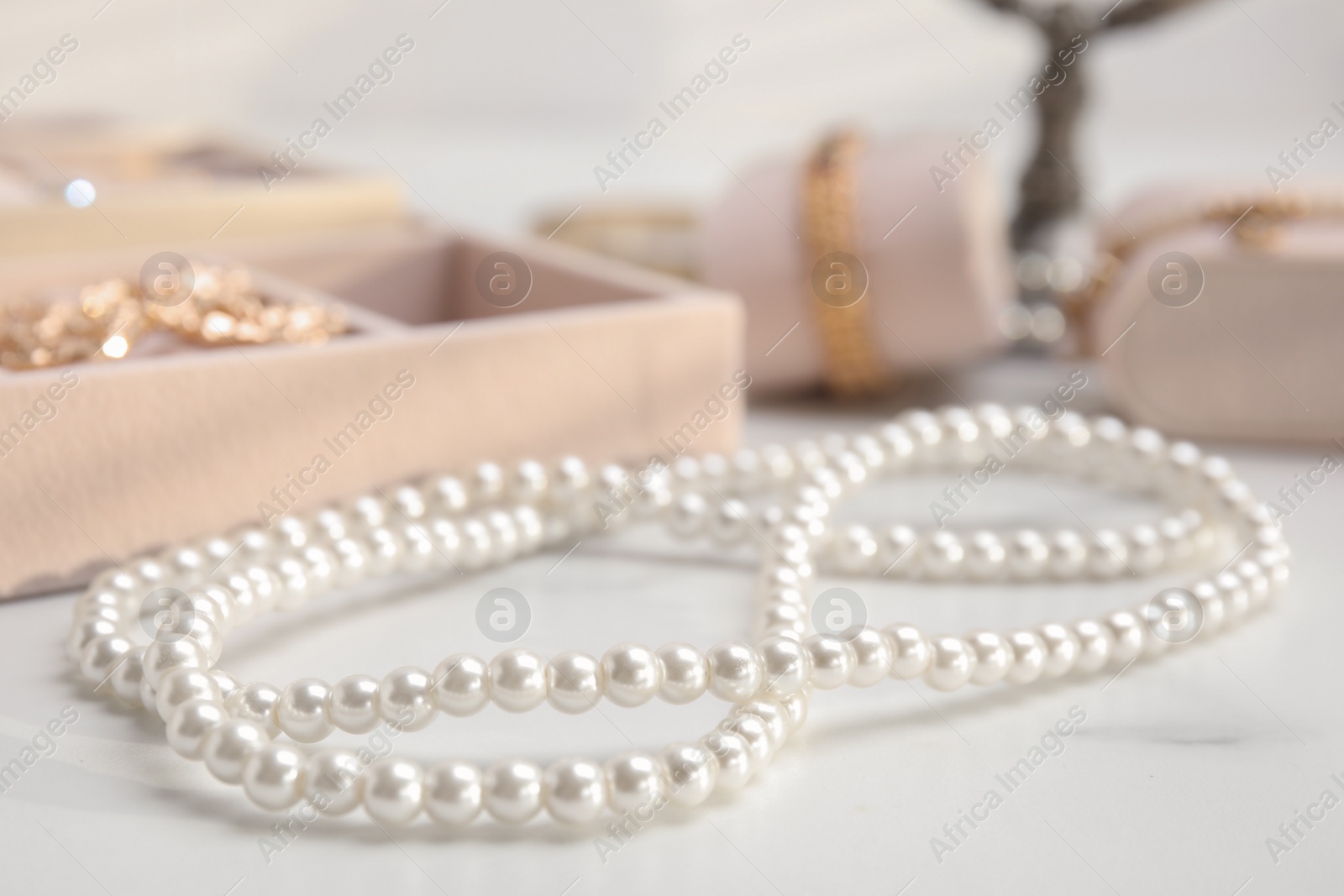 Photo of Elegant bijouterie on white marble table, closeup view