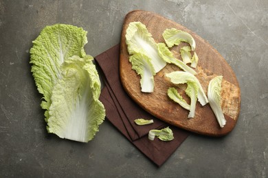 Pieces of fresh Chinese cabbage on gray textured table, top view