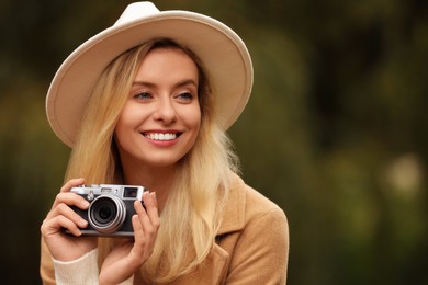 Photo of Autumn vibes. Portrait of happy woman with camera outdoors, space for text