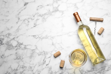 Photo of Glass and bottle with white wine on marble background, flat lay. Space for text