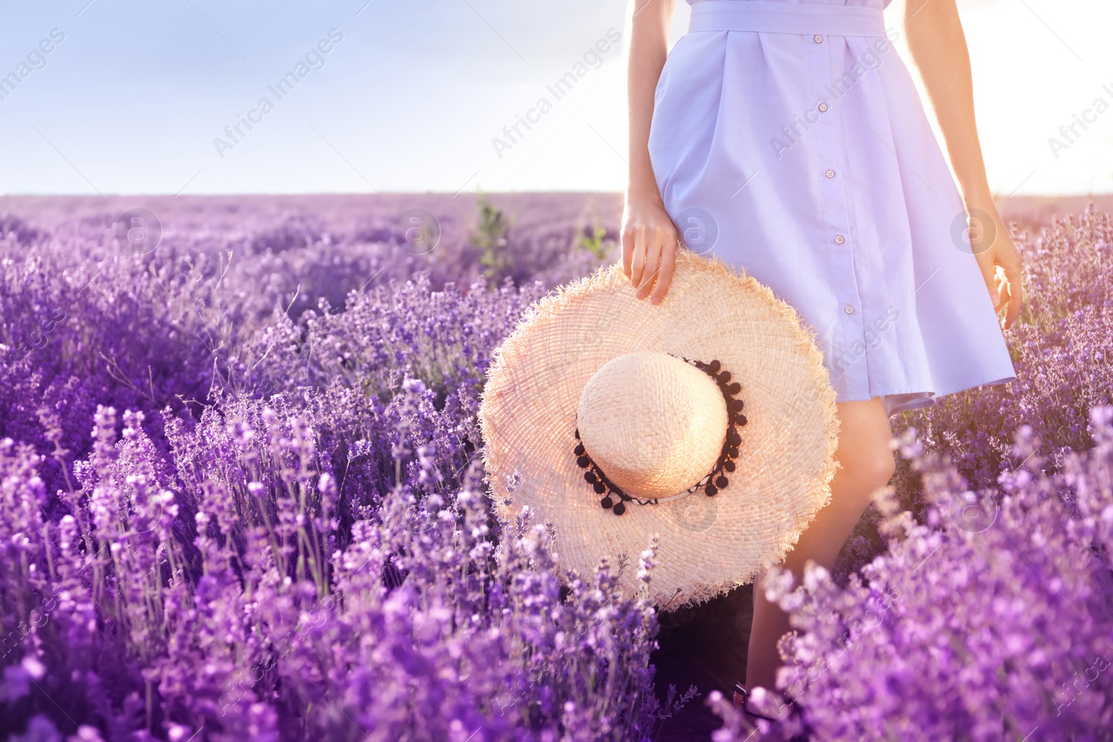 Photo of Young woman with hat in lavender field on summer day, closeup