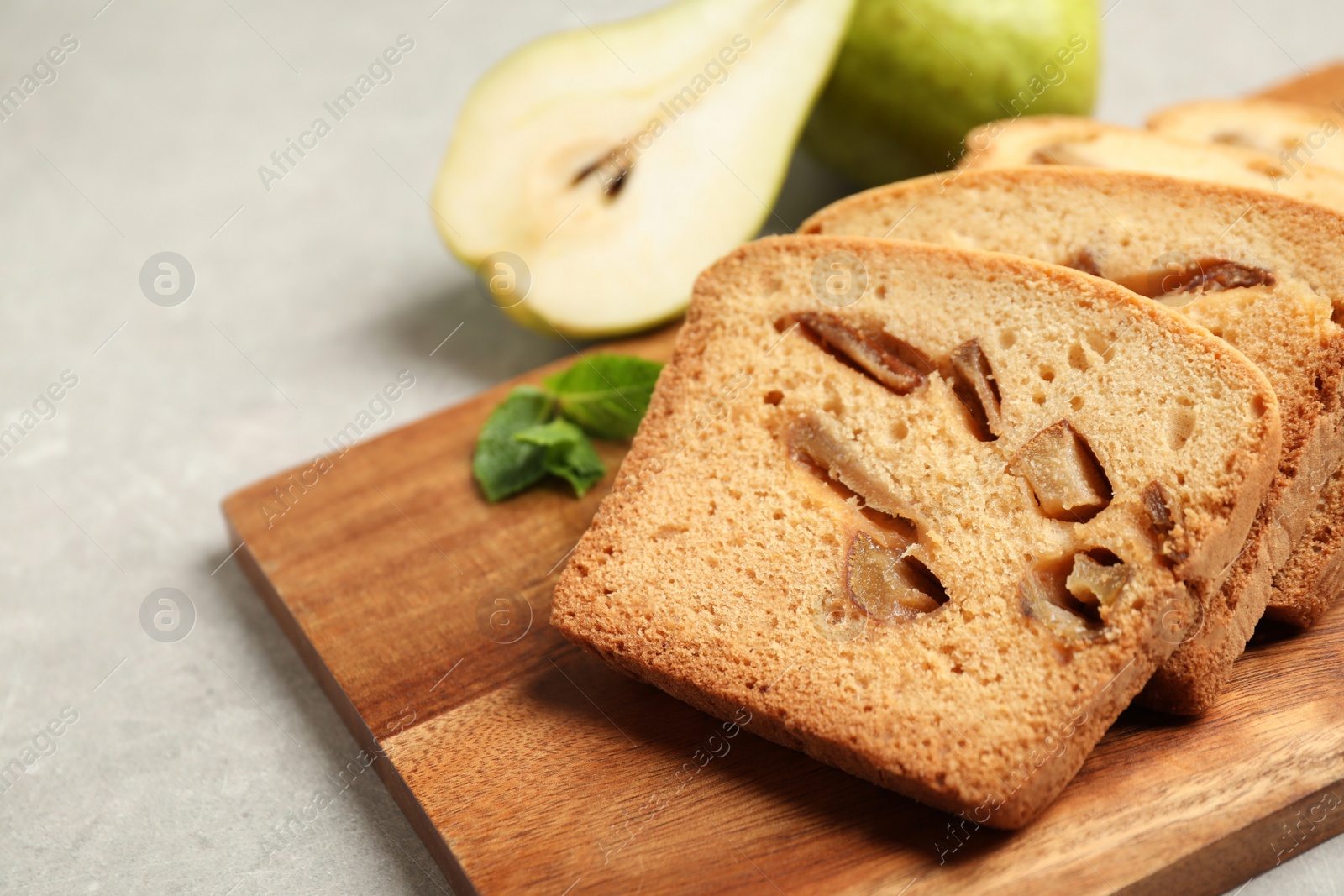 Photo of Slices of tasty pear bread on light grey table, closeup. Homemade cake