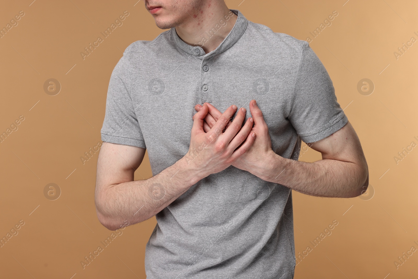 Photo of Man suffering from heart hurt on beige background, closeup