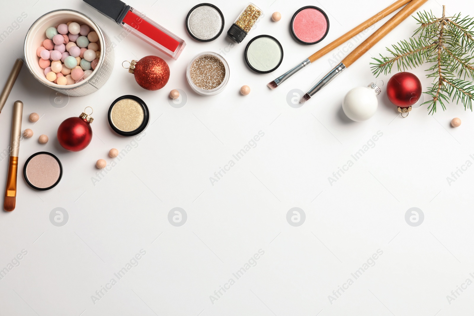 Photo of Flat lay composition with makeup products and Christmas decor on white background. Space for text