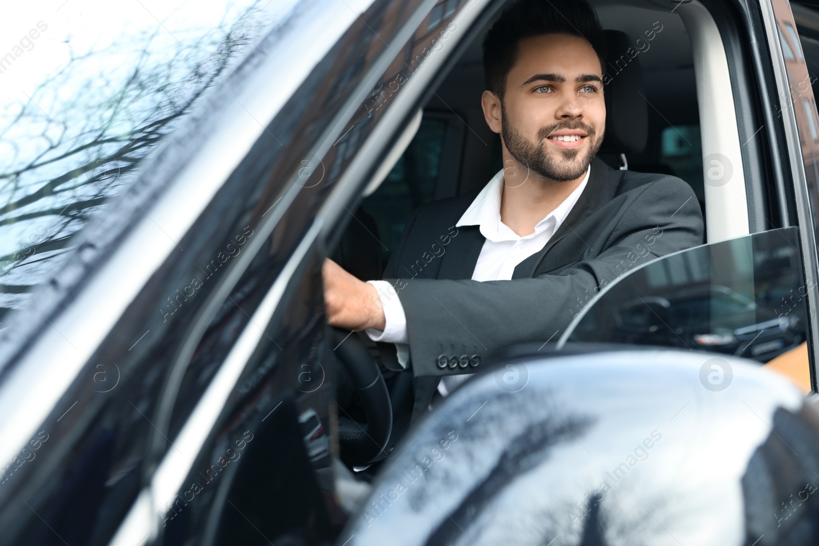 Photo of Handsome young man driving his modern car