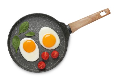 Tasty cooked chicken eggs with tomato in frying pan isolated on white, top view