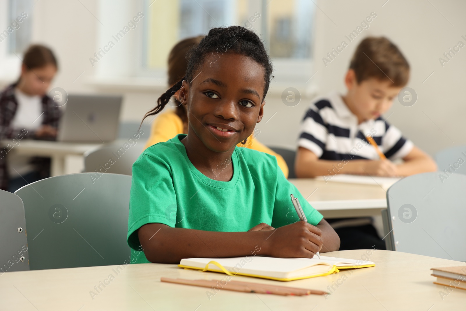 Photo of Portrait of smiling little boy studying in classroom at school