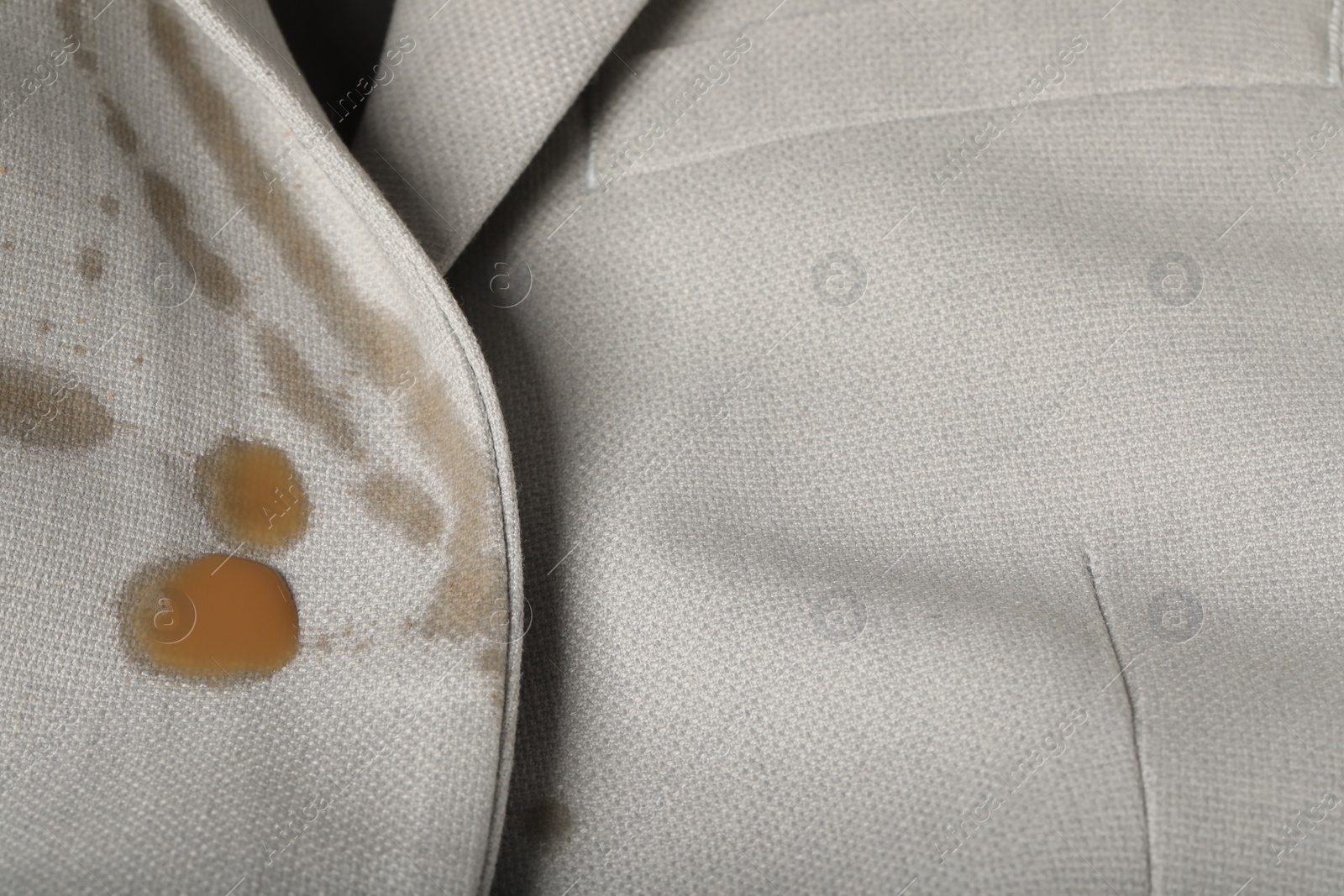 Photo of Dirty jacket with stain of coffee as background, closeup